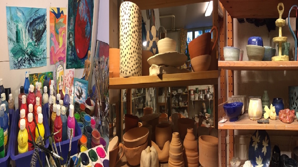 Hyllor med färgburkar, penslar och krukor.