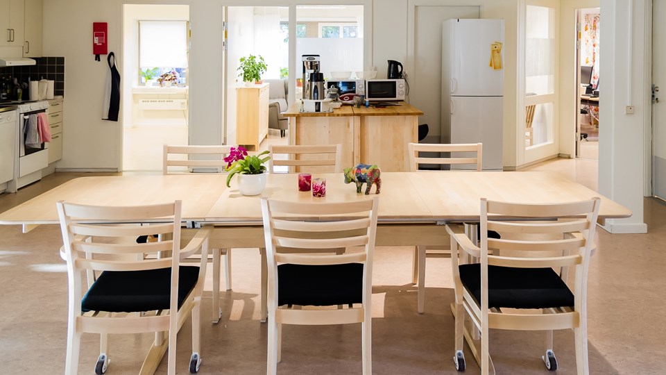 Ett bord med stolar i ett öppet kök.