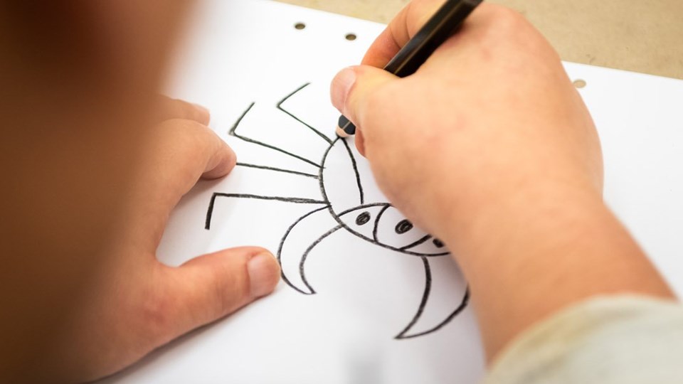 Ett barn som ritar en teckning.