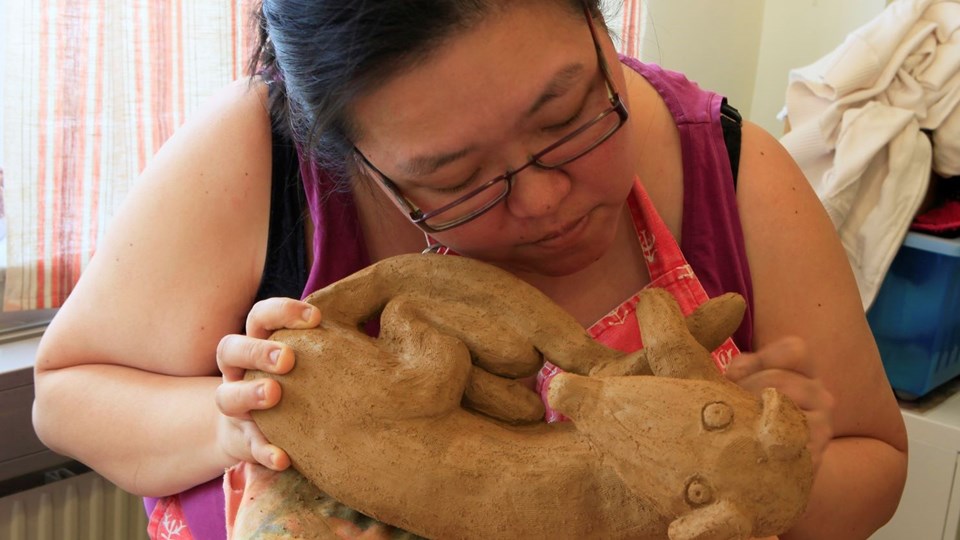 En person som håller en skulptur av en hund.
